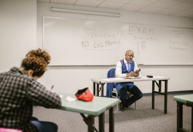 Candidatos fazem uma prova em sala de aula enquanto são acompanhados por um fiscal.
