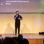 Homem fala ao microfone em um palco durante uma conferência no Brasil.