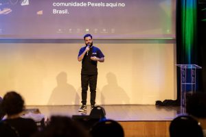 Homem fala ao microfone em um palco durante uma conferência no Brasil.