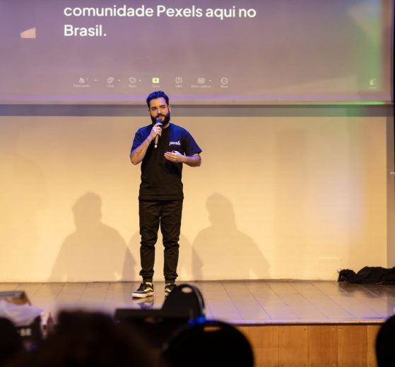 Homem fala ao microfone em um palco durante uma conferência no Brasil.