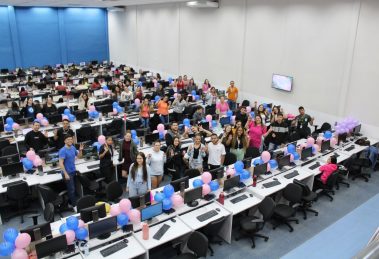 Grupo diverso de colegas participa de uma confraternização em ambiente interno decorado com balões coloridos.