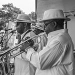 Banda de jazz se apresenta ao ar livre com saxofone e trompete.