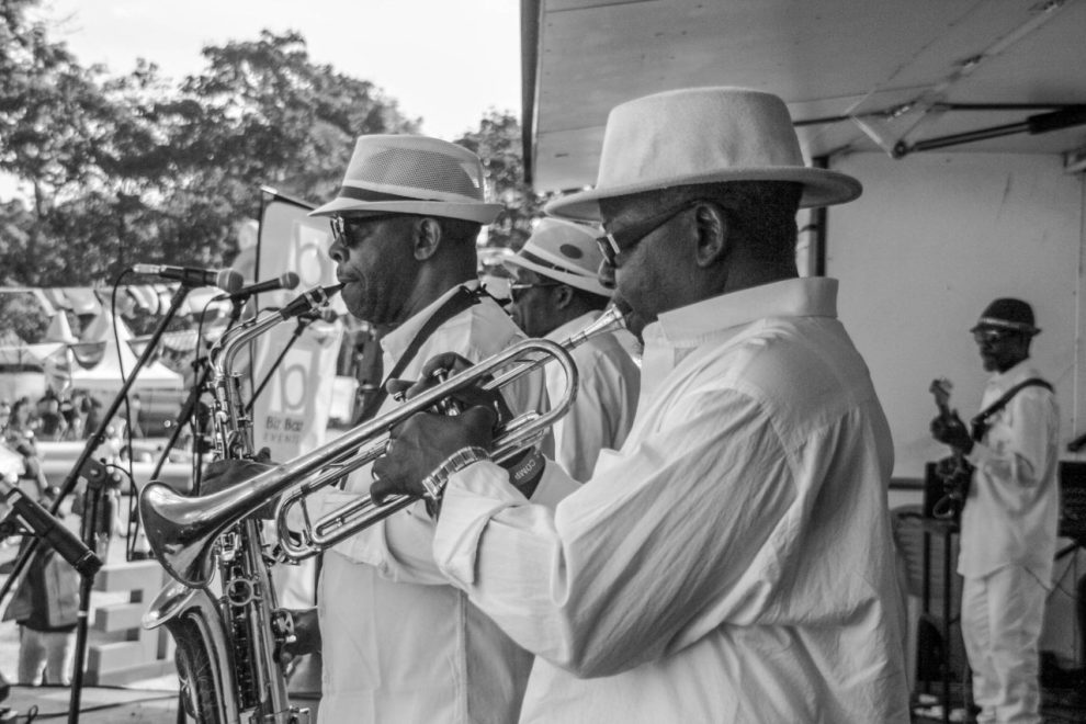 Banda de jazz se apresenta ao ar livre com saxofone e trompete.