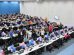 Grupo diverso de colegas participa de uma confraternização em ambiente interno decorado com balões coloridos.